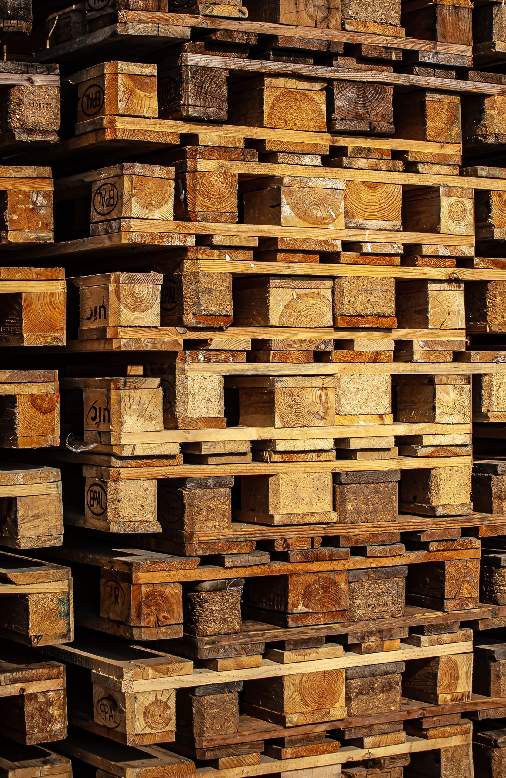 Servicios Close-up of stacked wooden pallets outdoors, showcasing industrial storage.